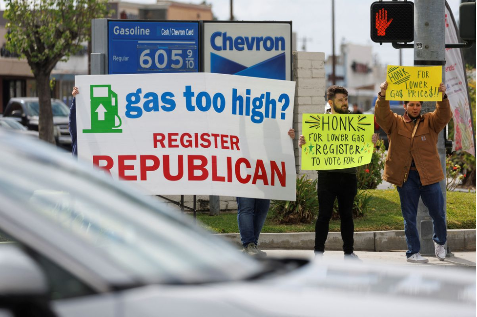 Republican activists seek drivers' attention as they work to register voters to their party at a gas station in Garden Grove, California, U.S., March 29, 2022. Picture taken March 29, 2022. REUTERS/Mike Blake